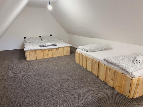 two twin beds in a room with a attic at Drevenica M&P 2 in Bešeňová