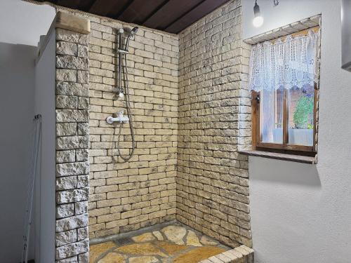 a bathroom with a brick shower with a window at Drevenica M&P 2 in Bešeňová
