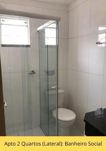 a bathroom with a toilet and a glass shower at Residencial Dona Naime in Bombinhas