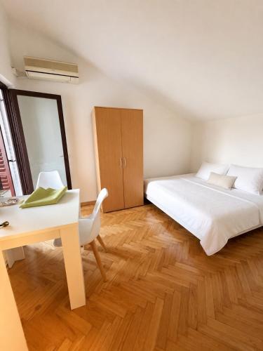 ein Schlafzimmer mit einem Bett, einem Tisch und einem Schreibtisch in der Unterkunft Aurra Studio in Budva