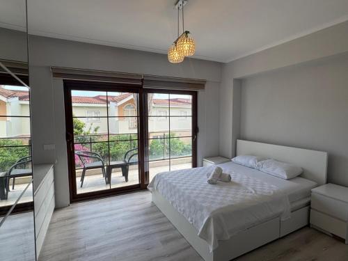 a bedroom with a bed and a large window at Sadev Turizm Belek Family Villas in Belek