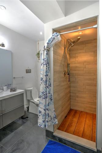 a bathroom with a shower with a wooden wall at Seaside Saloon Hot Tub Getaway in Sequim