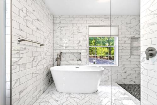 a white bathroom with a tub and a window at Calm Water Cove in Nebo