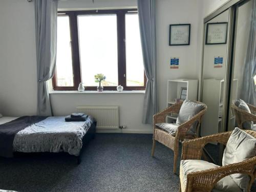 a bedroom with a bed and a chair and a window at Silver Tides House in Greenock