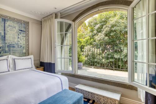 a bedroom with a bed and a window at Casa Talavera by Tasman in Mexico City