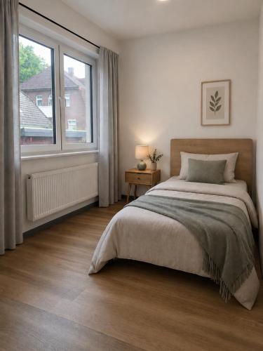 a bedroom with a bed and a large window at Blue Stay Bremen in Bremen