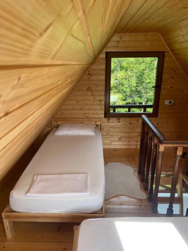 a bed in a wooden room with a window at Silent mode in Bijelo Polje