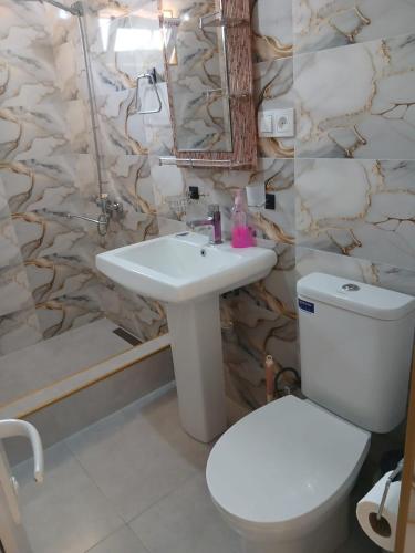 a bathroom with a white toilet and a sink at Light House in Kutaisi