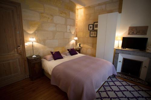 um quarto com uma cama grande e uma lareira em MAISON D'HÔTES "Bordeaux Wine Lodge" em Bordeaux