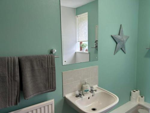 a bathroom with a sink and a mirror at Silver Tides House in Greenock