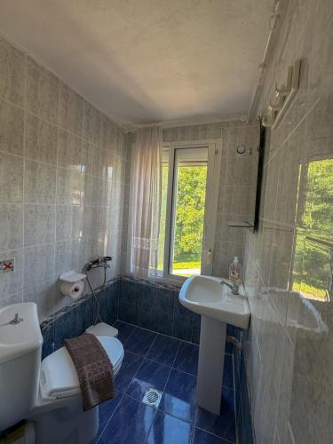 a bathroom with a sink and a toilet and a window at Casa Helios Fourka Beach Retreat in Skala Fourkas