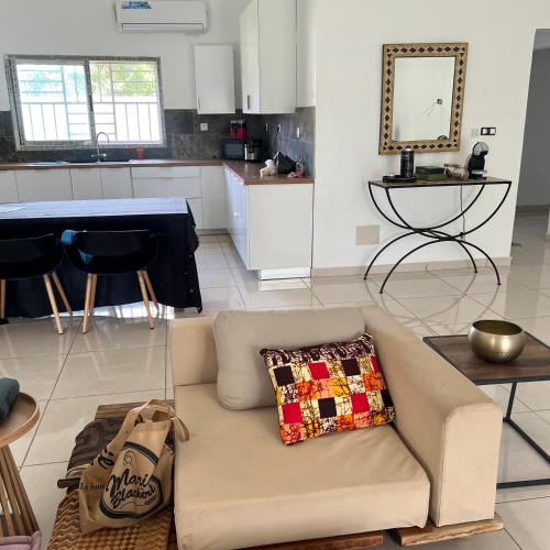 a living room with a couch and a kitchen at La Villa Fleur d'Edene in Abidjan
