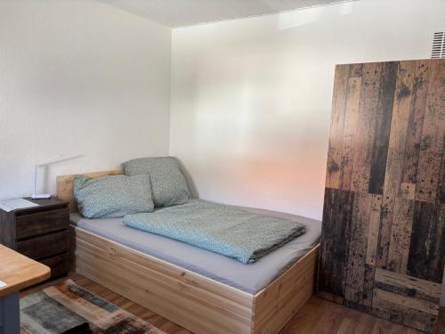 a bed in a room with a wooden bench at Neubeginn 2 - Zimmer A in Hildburghausen