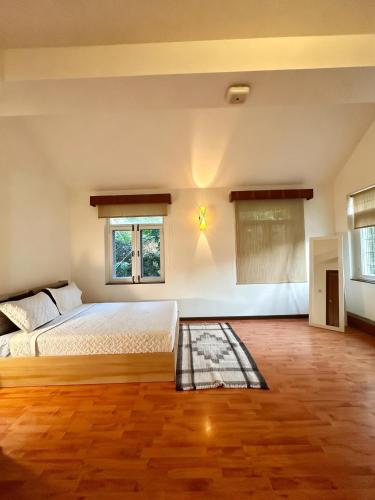 a bedroom with a large bed and two windows at Winston's Speakeasy & Inn in Pātan