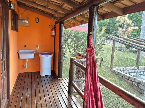 a bathroom with a toilet on a wooden deck at Residencial Hibiscos - Vista Mar in Garopaba