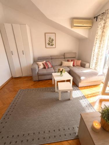 a living room with a couch and a table at Central Nesst Budva in Budva