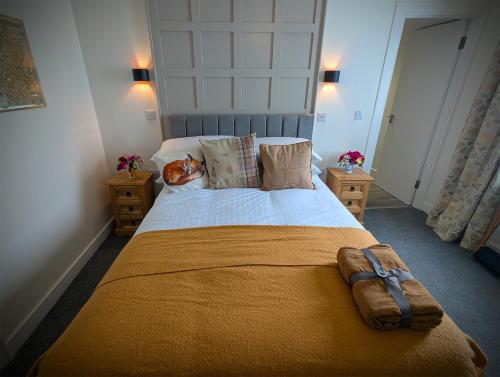 a bedroom with a large bed with a yellow blanket at The Wigtown Ploughman in Wigtown