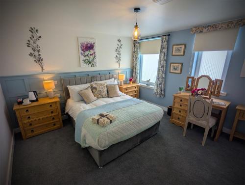 a bedroom with a bed with a teddy bear on it at The Wigtown Ploughman in Wigtown