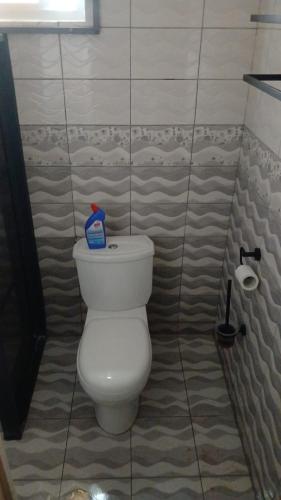 łazienka z białą toaletą w kafelkowym pomieszczeniu w obiekcie Mielichi w mieście Paramaribo
