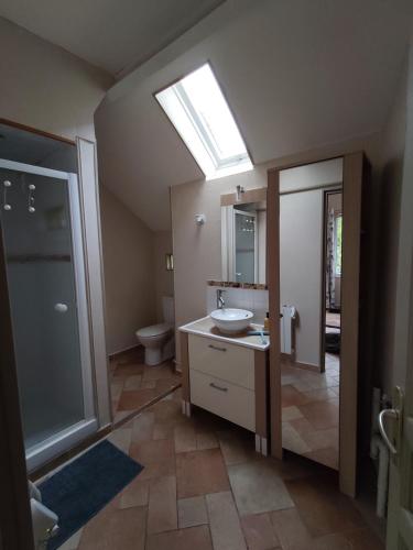 a bathroom with a sink and a toilet and a skylight at Maison de campagne proche Giverny La Casita de Bemi in Bois-Jérôme-Saint-Ouen
