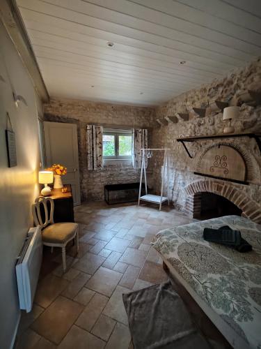 a bedroom with a fireplace and a stone wall at Maison de campagne proche Giverny La Casita de Bemi in Bois-Jérôme-Saint-Ouen