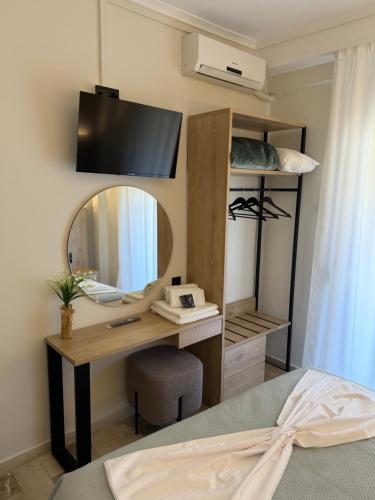 a bedroom with a desk with a mirror and a bed at Hotel Angela in Asprovalta