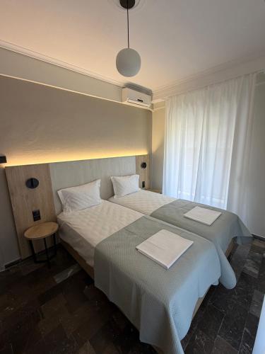 a hotel room with two beds and a window at Hotel Angela in Asprovalta