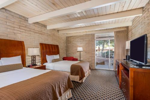 a hotel room with two beds and a flat screen tv at Kayenta Monument Valley Inn in Kayenta