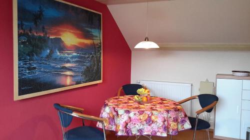 a dining room with a table with chairs and a painting at Ferienwohnung Krallert in Rennertshofen