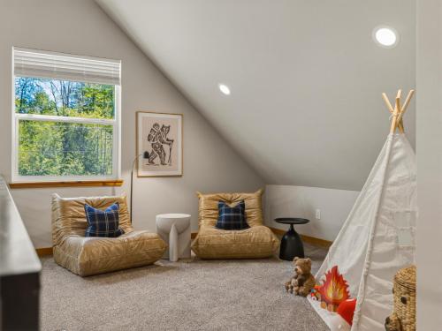 a attic room with two chairs and a bed at Rainier Spa Cabin 7 Minutes to Park in Ashford