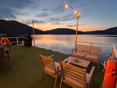 a deck of a boat with a table and chairs at Casa pe lac Bicaz in Bicaz