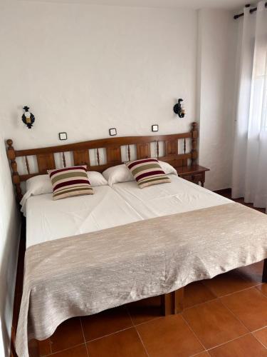 a bed with two pillows on it in a bedroom at Hotel Apolo XI in Tahivilla