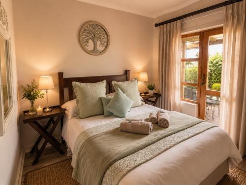 a bedroom with a large bed with two towels on it at Ash River Lodge in Clarens
