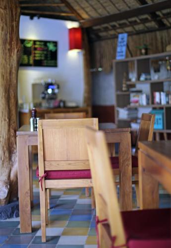a dining room with wooden tables and chairs and a table and chairsearcher at The Calmtree Bungalows in Canggu