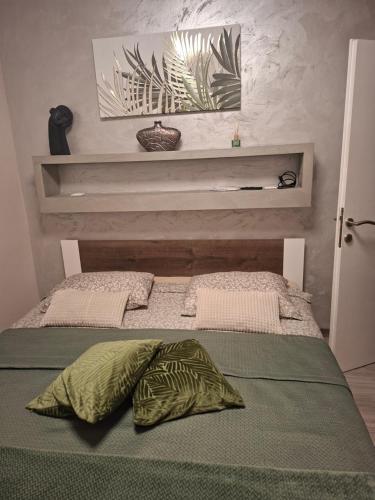 a bed with two pillows on it in a room at Apartman IDEA in Rabac