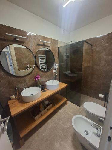 a bathroom with two sinks and a toilet and a mirror at Apartman IDEA in Rabac