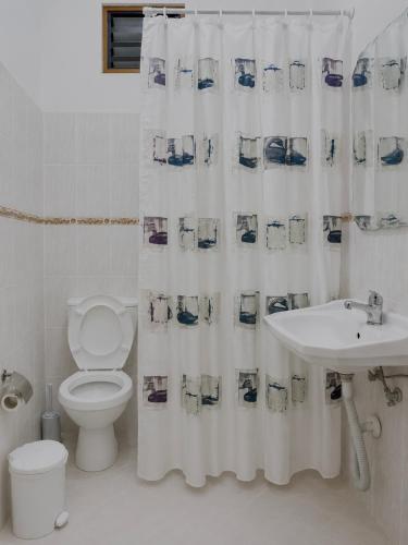 a bathroom with a toilet and a shower curtain at Vila Vladmir Sela in Ksamil