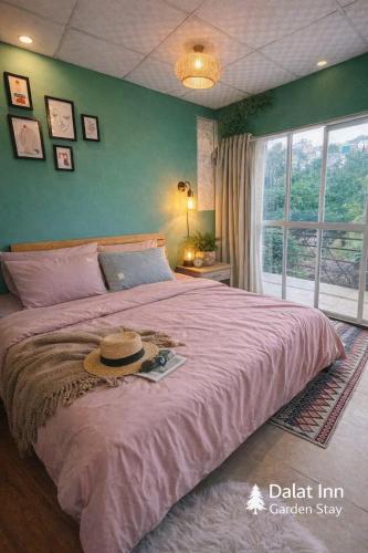 a bedroom with a large bed with a hat on it at Pine Aura Dalat Inn in Da Lat
