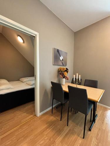 a dining room with a table and chairs and a bed at Undredal Fjord Apartments in Undredal