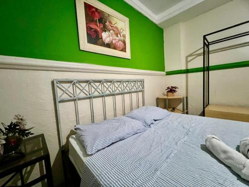 a bedroom with a bed with a green wall at Pousada Requinte in Vila Velha