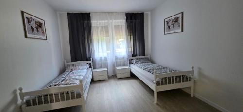 a bedroom with two beds and a window at RM Apartaments in Bochum