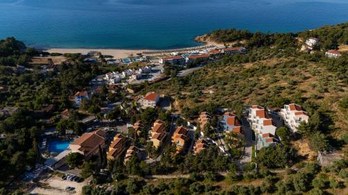 an aerial view of a resort on a hill next to the ocean at Zoe Hotel, Trypiti Beach Resort & Hive water park in Limenaria