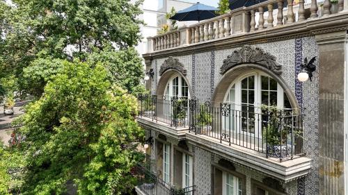 a building with two windows and a balcony at Casa Talavera by Tasman in Mexico City