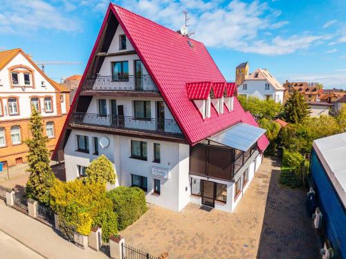 an overhead view of a house with a red roof at Pensjonat Tadeusz i Apartamenty w Darłówku in Darlowko