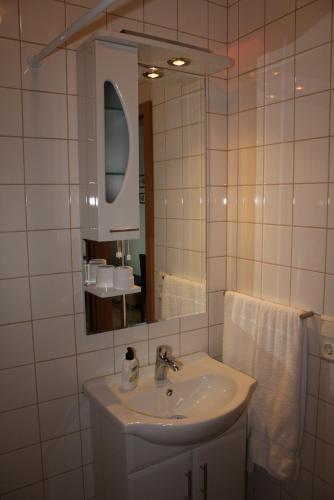a white bathroom with a sink and a mirror at Hofsstadir Farmhouse in Hofstaðir