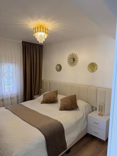 a bedroom with a large bed and a chandelier at Villa Mery Montserrat in Piera