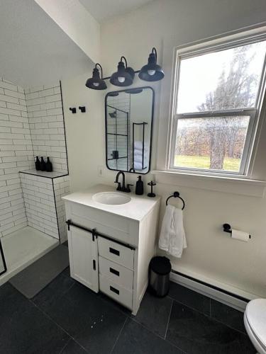 a white bathroom with a sink and a mirror at Cozy Catskill Escape in Catskill