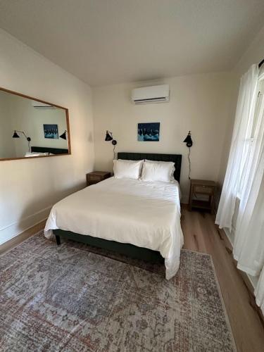 a bedroom with a large white bed and a rug at Cozy Catskill Escape in Catskill