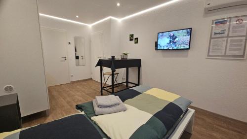 a room with a bed and a tv on the wall at Ferienzimmer Saarlouis in Saarlouis