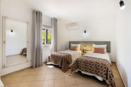 a bedroom with two beds and a large mirror at Quinta Terruta by Ocvillas in Albufeira